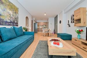 a living room with a blue couch and a table at Modern flat in the heart of Port of Piraeus (D2) in Piraeus