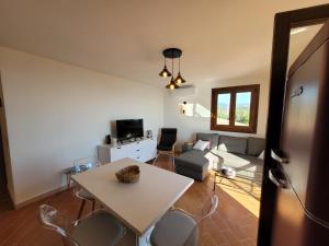 uma sala de estar com uma mesa e um sofá em Villa Lagoon Solenzara em Togna