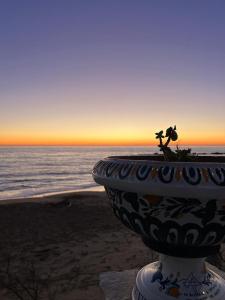 a planter on the beach with the ocean in the background at Valenti rooms & relax in Villaggio Mosè