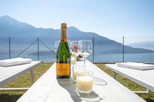 una botella de vino sentada en una mesa con copas en Valarin Luxury Apartments & Wellness, Vercana by Rent All Como, en Vercana