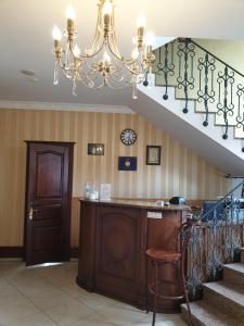 un escalier avec un lustre et une table en bois dans l'établissement Shelter Hotel & Restaurant, à Kolodezhno