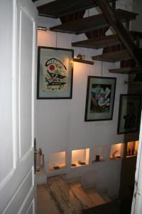 a hallway with paintings on the walls of a house at la maison de l'architecte in Hammamet