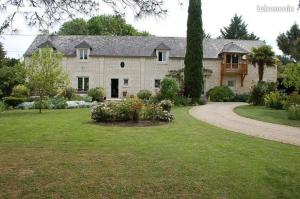 a large stone house with a driveway in a yard at Rêves & Rivière in Rivière