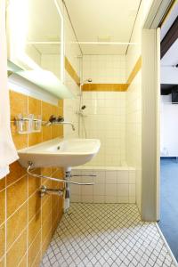 La salle de bains est pourvue d'un lavabo et d'une baignoire. dans l'établissement Hotel Untertor - 24H Self Check-in, à Altstätten