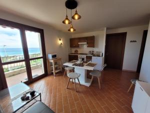 uma cozinha com mesa e cadeiras e vista para o oceano em Villa Lagoon Solenzara em Togna