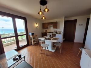 cocina con mesa y sillas y vistas al océano en Superbe Villa, incroyable vue mer, avec piscine privative à Solenzara, en Togna