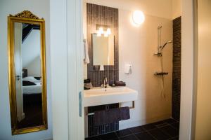 a bathroom with a sink and a mirror at Hotel de Reiziger in Ottersum