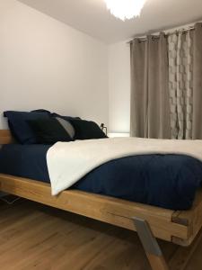 a bedroom with a bed with blue and white sheets at Le chalet des étoiles in La Mongie