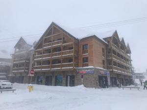 a large building in the snow in front at Le chalet des étoiles in La Mongie