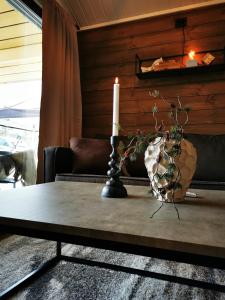 a candle on a table in a living room at Min Ája in Karasjok