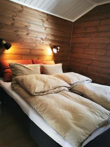 a large bed in a room with a wooden wall at Min Ája in Karasjok