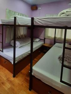 two bunk beds are in a room with at Margik Backpackers Hostel in Pokhara