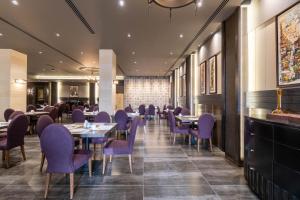 a dining room with purple chairs and tables at Ambassador, a Boutique Hotel in Amman