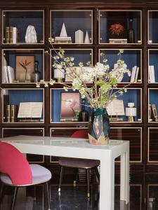 a vase of flowers on a white table in a room at Vista Palazzo in Verona