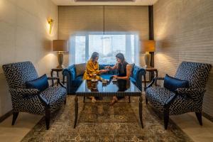 Ambassador, a Boutique Hotel في عمّان: وجود سيدتان جالستان حول طاولة في غرفة