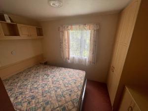 a small room with a bed and a window at A13 THE CHASE 8 Berth Caravan in Skegness