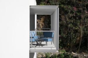 una sedia seduta sul portico di una casa di Zero Box Lodge Coimbra a Coimbra