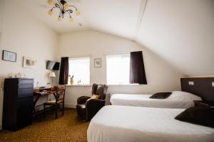 En eller flere senge i et værelse på Hotel de Reiziger