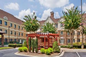 an apartment building with trees in front of it at Sonesta ES Suites Atlanta Alpharetta Avalon in Alpharetta