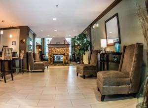 a waiting room with chairs and a fireplace at Sonesta ES Suites Atlanta Alpharetta Avalon in Alpharetta