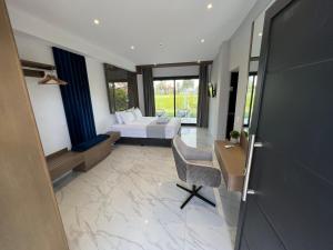 a hotel room with a bed and a desk and a desk at V luxury Suites in Pefkohori