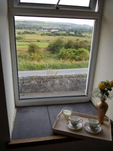 a table with two cups of coffee and a window at Hyfrydle Heights in Pen-y-groes