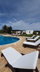 een zwembad met ligstoelen naast een resort bij CAN FARITZEO in Sant Rafael de Sa Creu