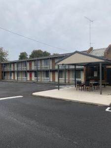 un edificio con una mesa de picnic al lado de una calle en LaTrobe Motel Morwell, en Morwell