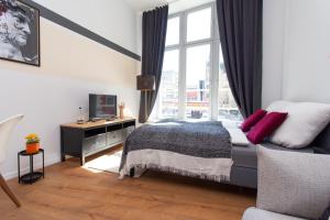 a bedroom with a bed and a desk and a window at FULL HOUSE Apartment Hotel in Halle an der Saale