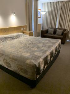 um quarto com uma cama grande e um sofá em LaTrobe Motel em Morwell