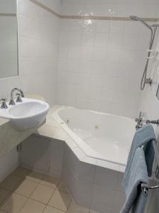 y baño blanco con lavabo y bañera. en LaTrobe Motel Morwell, en Morwell