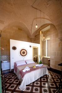 ein Schlafzimmer mit einem großen Bett in einer Steinmauer in der Unterkunft MIOE in Muro Leccese