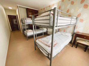 a bunk bed room with three bunk beds and a desk at Albergue O Cruceiro in Caldas de Reis