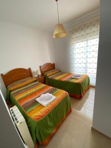 1 dormitorio con 2 camas y ventana en Armonía, en Cazorla