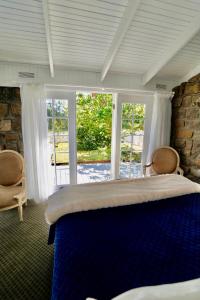 a bedroom with a large bed and a large window at Elegant bluestone cottage located at the Red Hill Peony Estate in Red Hill