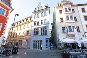 a person standing in front of some buildings at FULL HOUSE Apartment Hotel in Halle an der Saale