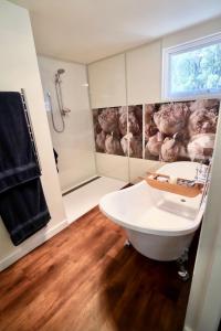 a bathroom with a tub and a sink and a shower at Elegant bluestone cottage located at the Red Hill Peony Estate in Red Hill
