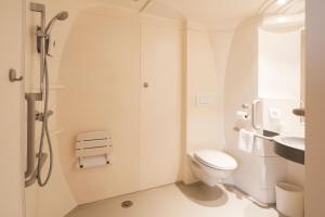 a white bathroom with a shower and a toilet at Premiere Classe Le Havre Centre-LES DOCKS in Le Havre +74 photos