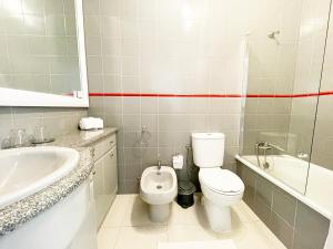 a bathroom with a toilet and a sink and a tub at CC - Casa da Costa in Costa Nova +8 photos
