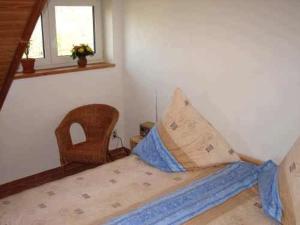 ein Schlafzimmer mit einem Bett mit einem Stuhl und einem Fenster in der Unterkunft Ferienwohnung im DG, Parkplatz vorm Haus, WLAN in Bielatal