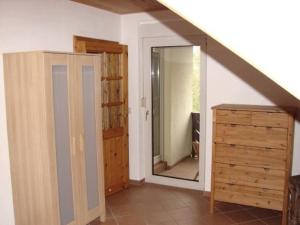 a room with a staircase and a dresser and a mirror at Ferienwohnung im DG, Parkplatz vorm Haus, WLAN in Bielatal