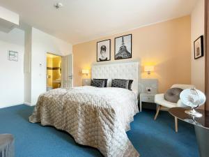 - une chambre avec un grand lit et une chaise dans l'établissement Rhein Hotel St. Martin, à Cologne
