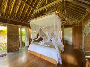a bed that has a canopy over it at Sawah Indah Villa in Sidemen