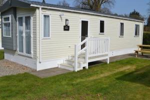 a mobile home with a staircase and a bench at Callander Woods Holiday Park in Callander +15 photos
