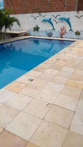 una piscina de agua azul frente a una pared en Casa Majorlandia, en Majorlândia