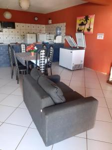 comedor con sofá, mesa y sillas en Casa Majorlandia en Majorlândia