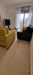een woonkamer met een gele bank en een televisie bij Shoham apartment in Eilat