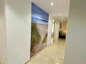a hallway with a wall mural of a beach at Chicflat Avenida España Ideal para familias in Estepona