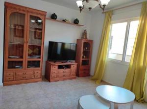 een woonkamer met een flatscreen-tv en een tafel bij Chicflat San Roque Estepona in Estepona