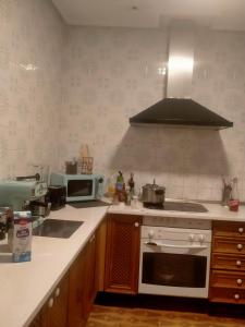 a kitchen with a stove and a microwave at El Refugio in Villarrobledo